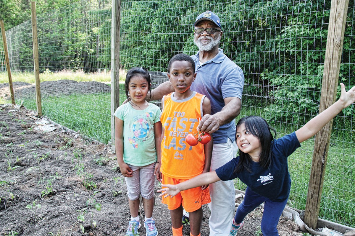 The Rev. Robert Campbell uses the Rogers Road community garden to teach neighborhood children about nutrition, field-to-table and the math behind growing and preparing food. Photo by Mike Benson