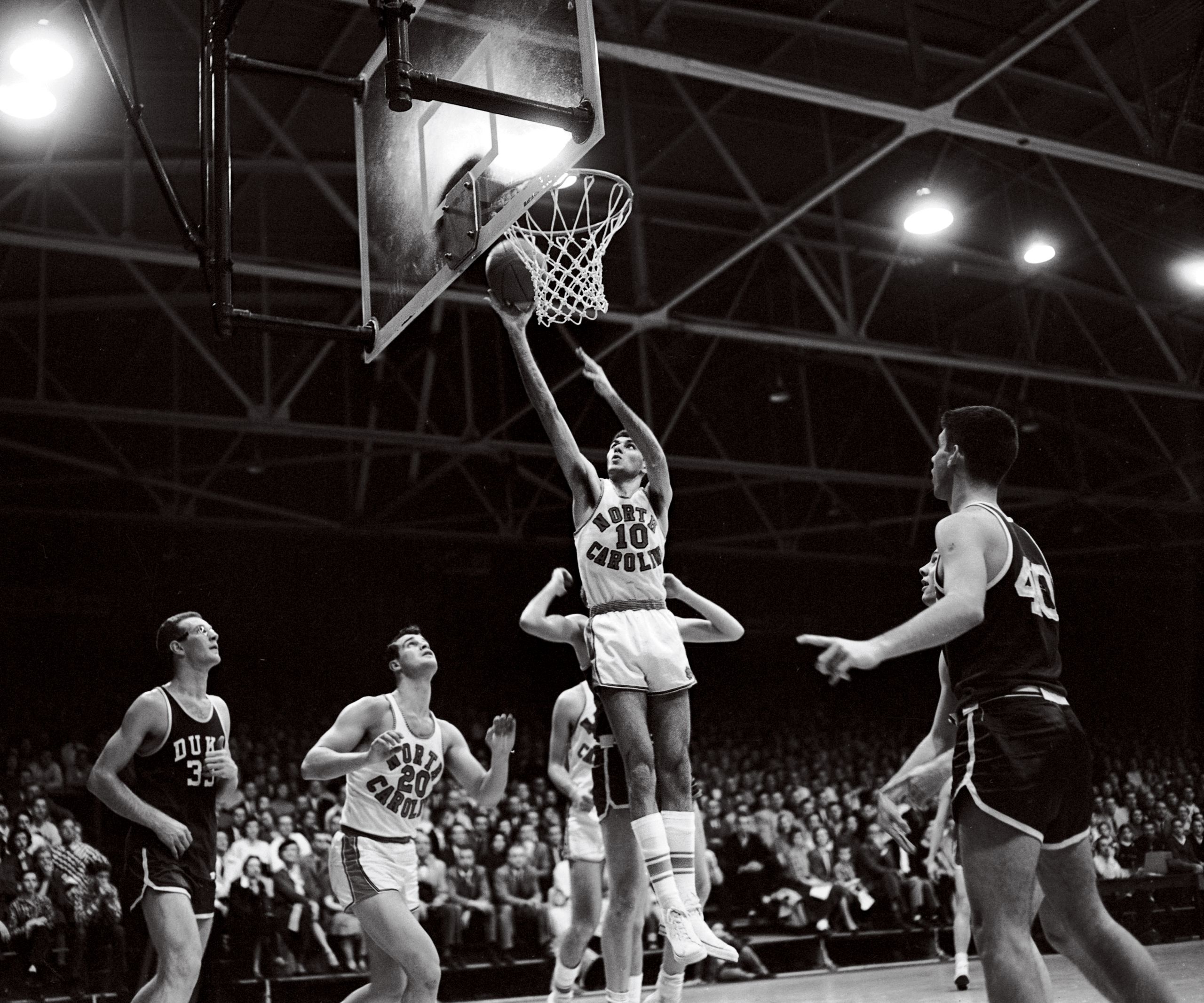 Rosenbluth uses his long reach against Duke on Feb. 9. Carolina took it, 75-73, one of three over the Blue Devils. No. 20 is Bob Young ’57, one of five  surviving members of the team. (North Carolina Collection photo)